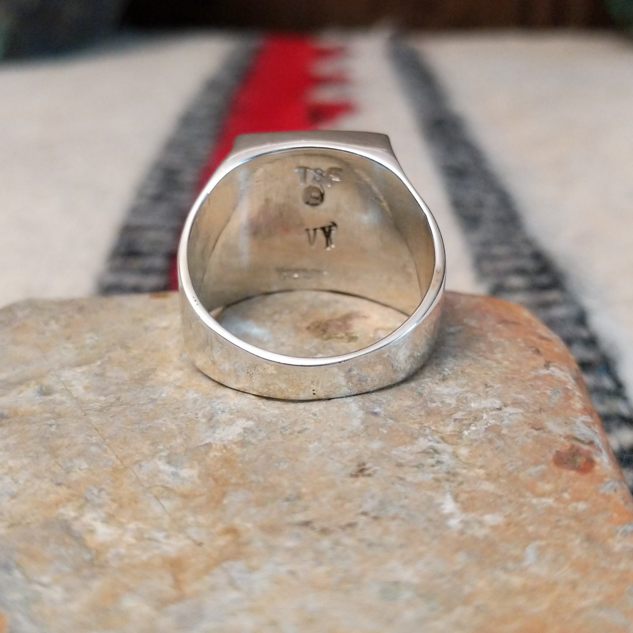 Navajo multistone inlay ring by V.Y. featuring a rectangular geometric design with turquoise, blue, purple, green, orange, and white inlay set in a wide polished silver band; underside view.