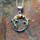 Handcrafted sterling silver multistone lizard pendant by R.I., featuring colorful inlay in a circular openwork Navajo design.