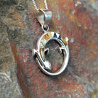 Handcrafted sterling silver multistone lizard pendant by R.I., featuring colorful inlay in a circular openwork Navajo design; side view.