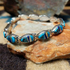 Navajo multistone inlay bracelet by V.J. with turquoise, lapis, and Mother of Pearl teardrop links in sterling silver.