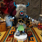 Navajo Ogre Kachina doll with gray fur-covered face, black horns with turquoise markings, open red mouth, pointed teeth, and green fabric apron.
