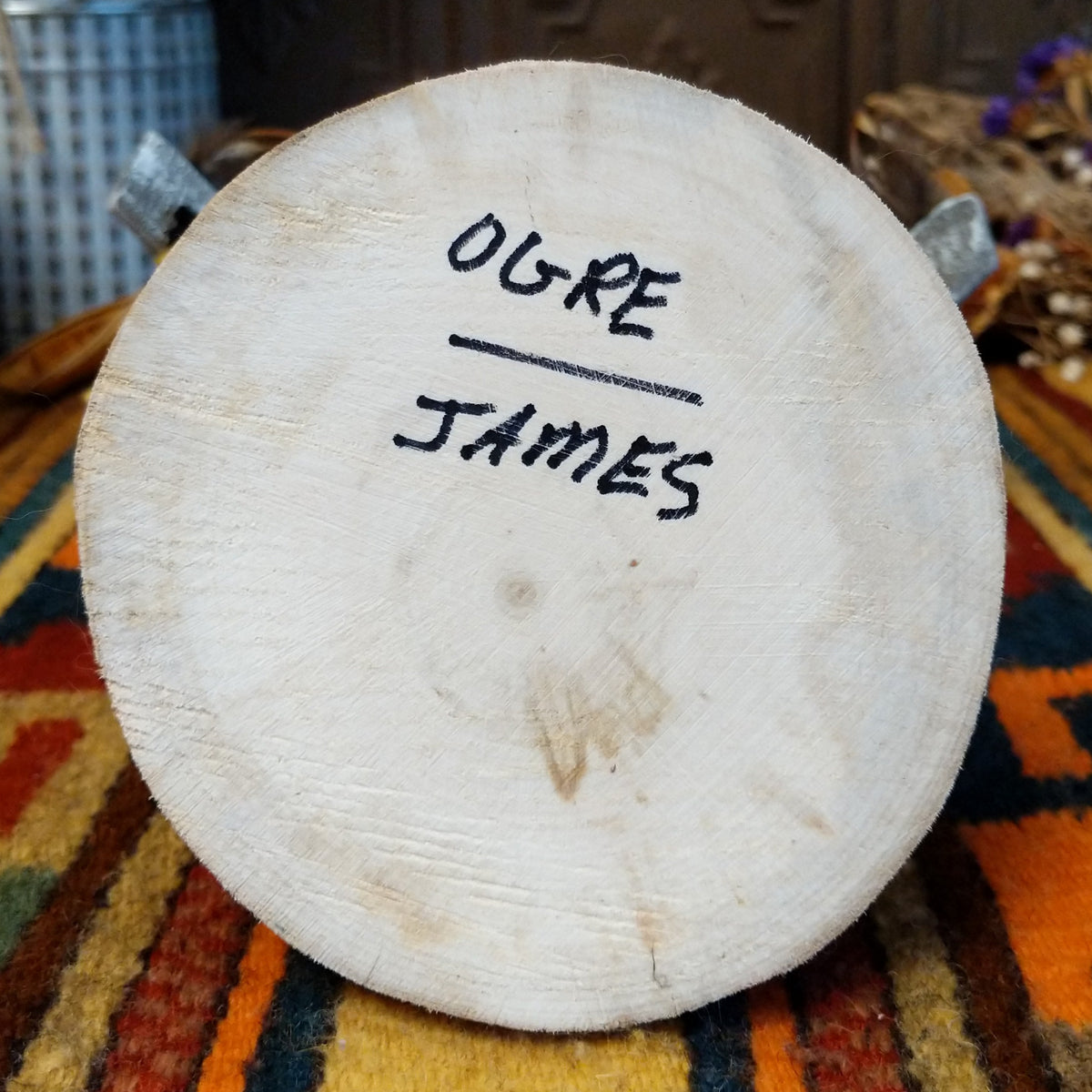 Underside of Navajo Ogre Kachina doll base with handwritten figure name and artist surname.