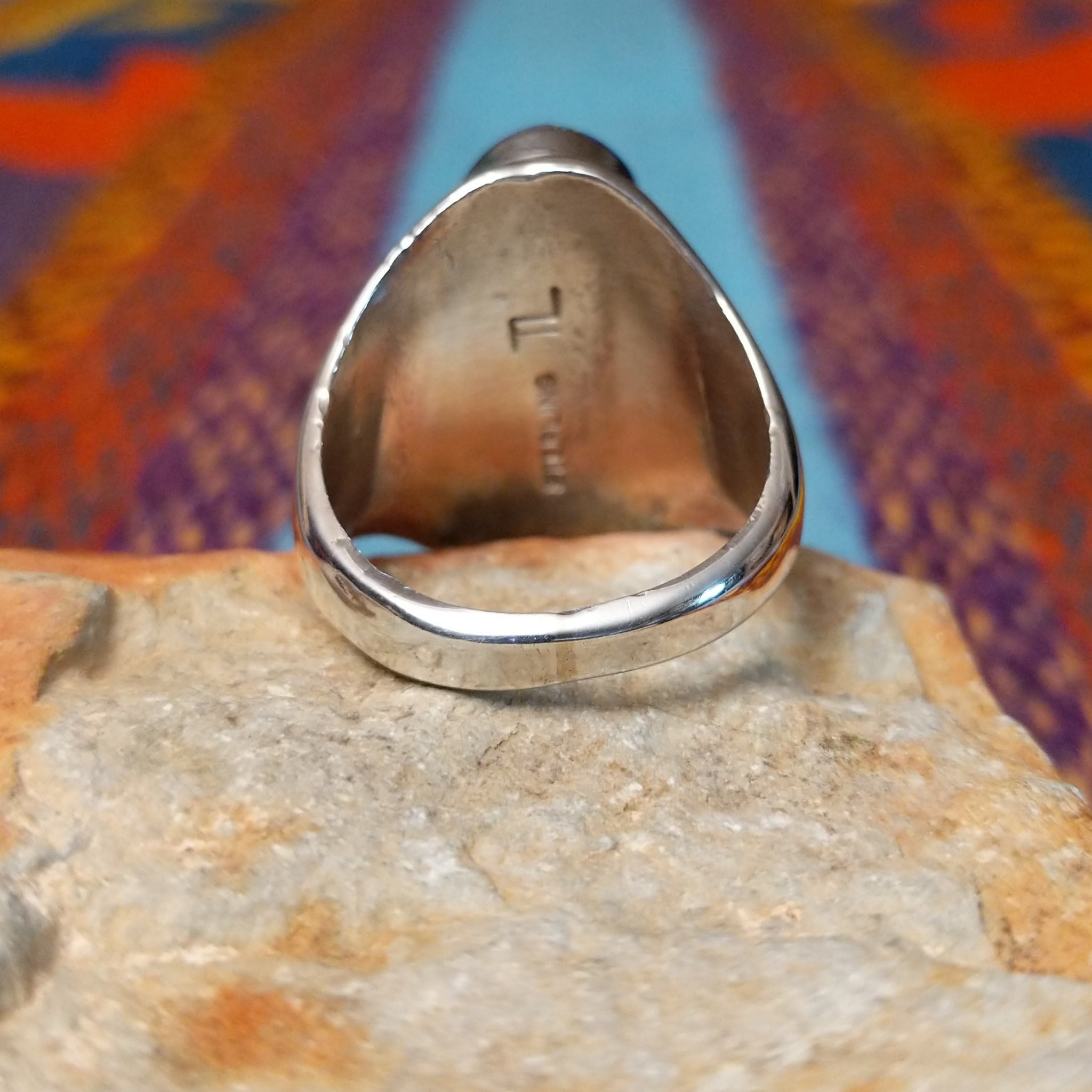 Navajo Oval Lapis Inlay Ring by T.L. featuring geometric blue lapis inlay with turquoise and red accents, Sterling Silver channels, and detailed stamped silverwork; underside view.