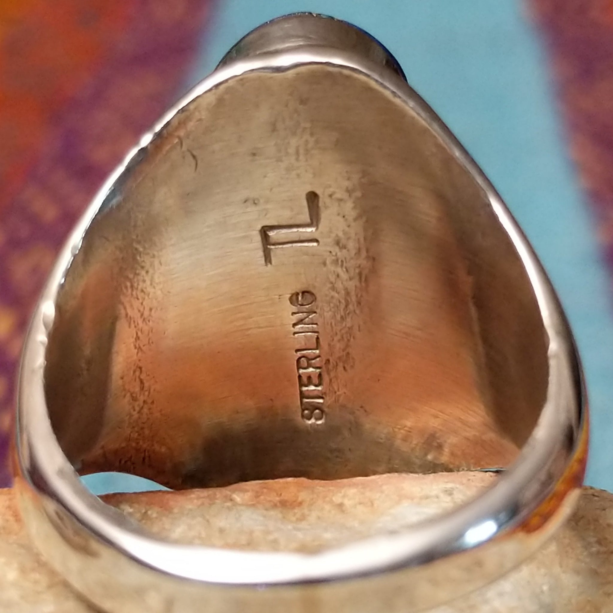 Navajo Oval Lapis Inlay Ring by T.L. featuring geometric blue lapis inlay with turquoise and red accents, Sterling Silver channels, and detailed stamped silverwork; artisan and Sterling Silver stamp.