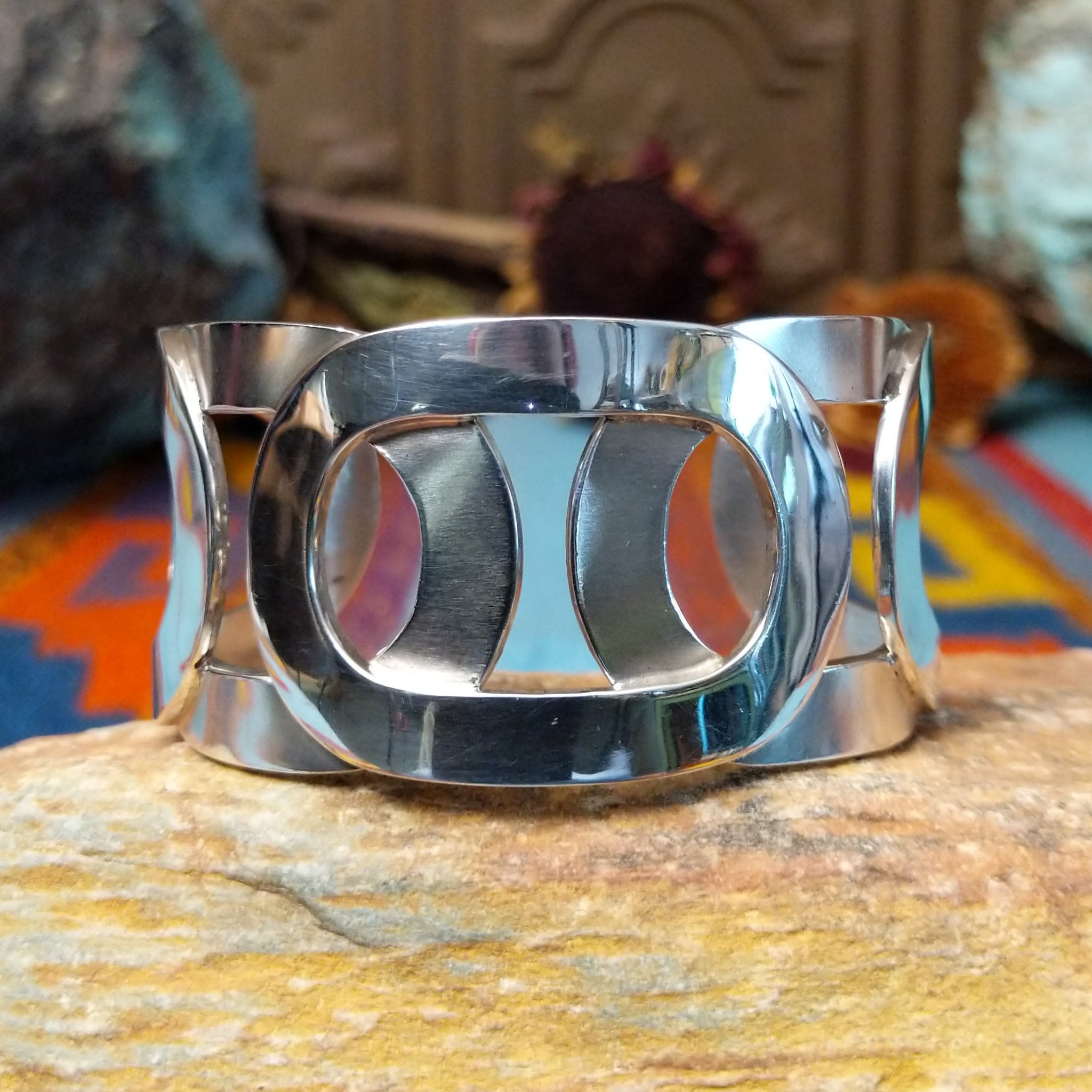 Wide Navajo silver cuff with polished overlapping bands and large open sections.