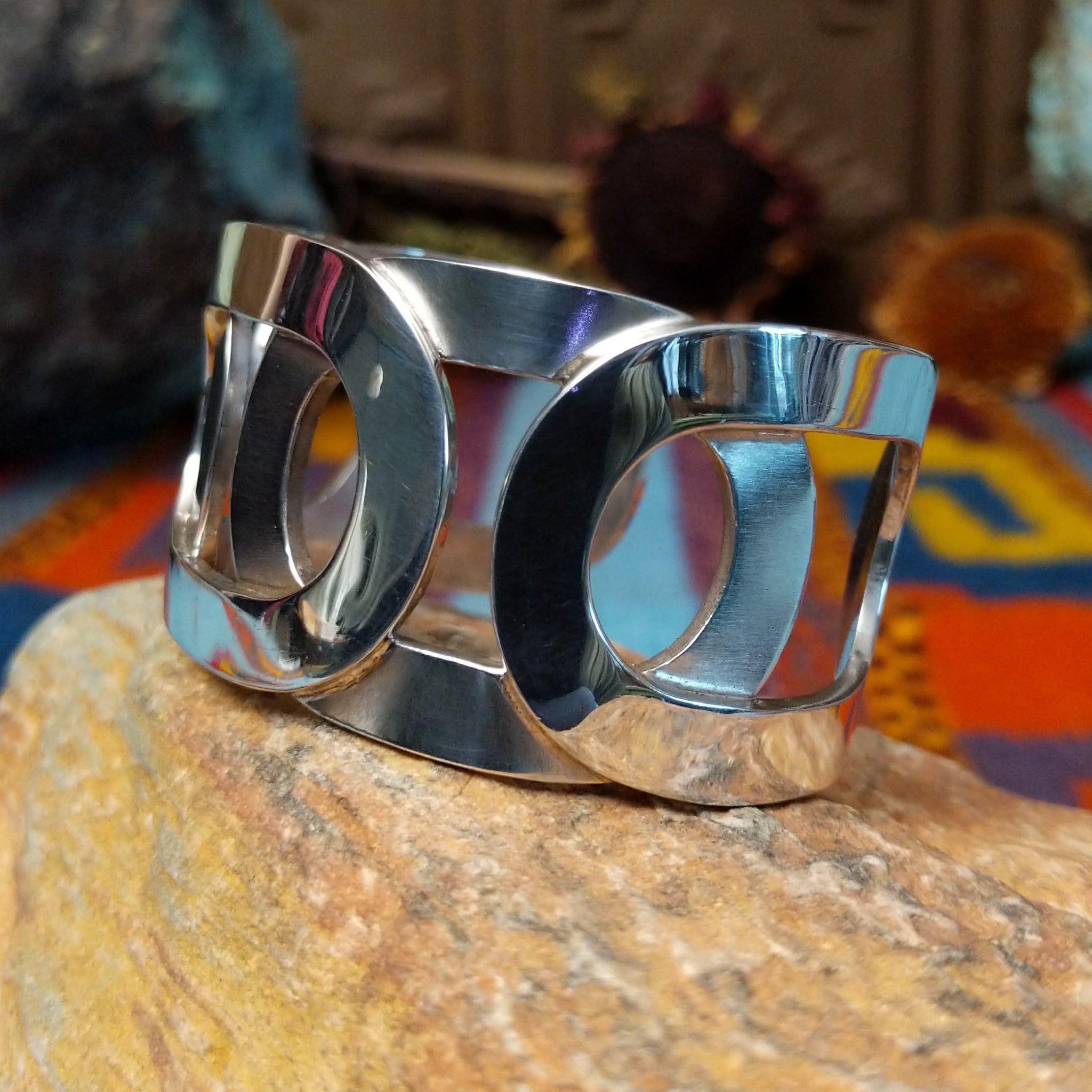 Wide Navajo silver cuff with polished overlapping bands and large open sections.