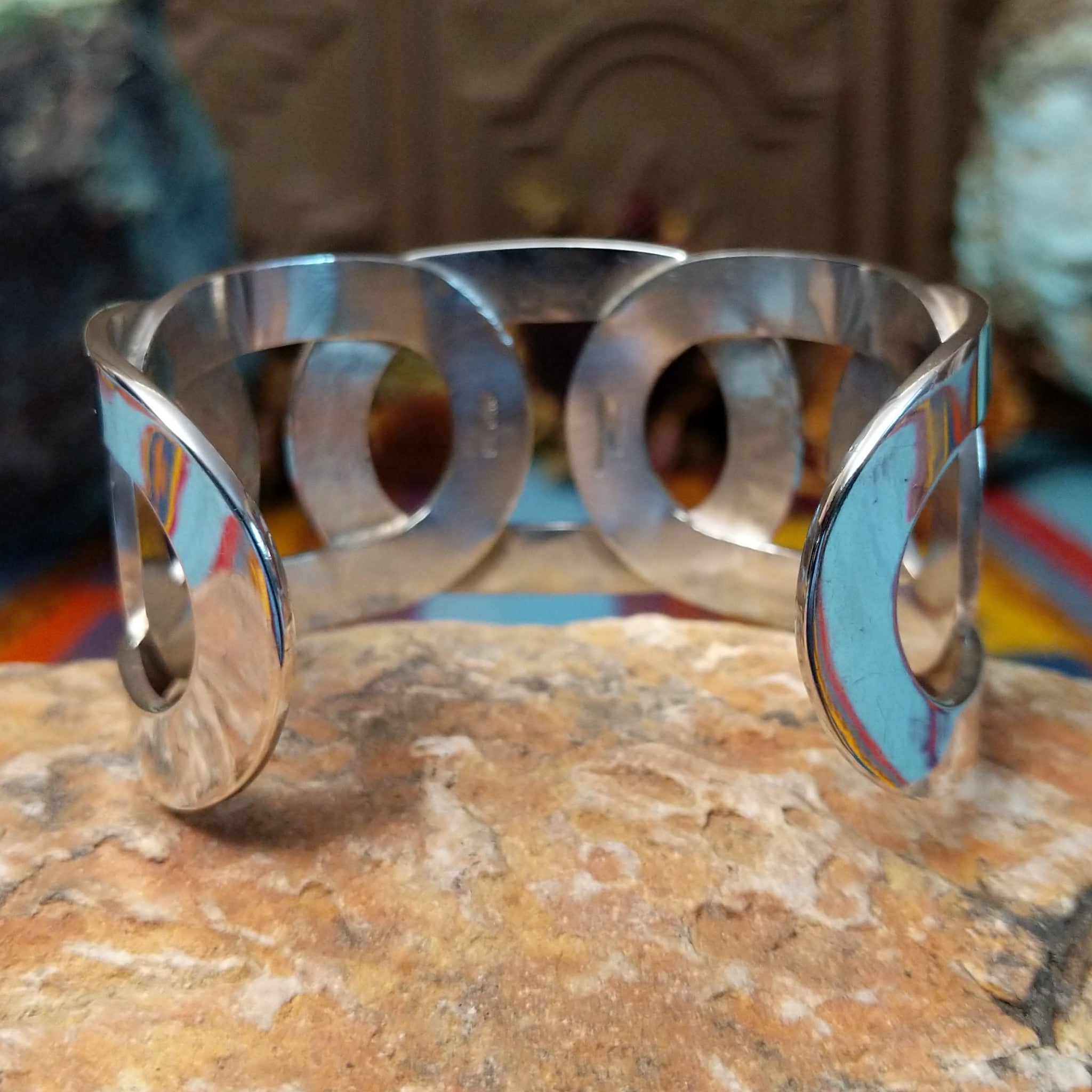 Wide Navajo silver cuff with polished overlapping bands and large open sections.