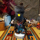 This unique Navajo Owl Kachina by Debbie James features a hand-painted wooden figure with a yellow and black owl beak, dark fur headdress, natural feathers, leather ties, decorative clothing, and a wooden display base.