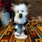 Navajo Owl Kachina doll with fluffy white fur, black eyes, yellow-trimmed beak, brown feathers around the head, and blue belt.