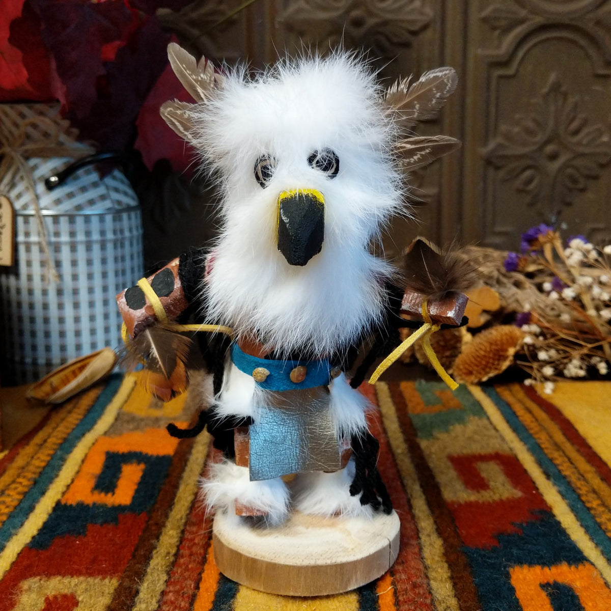 Navajo Owl Kachina doll with fluffy white fur, black eyes, yellow-trimmed beak, brown feathers around the head, and blue belt.