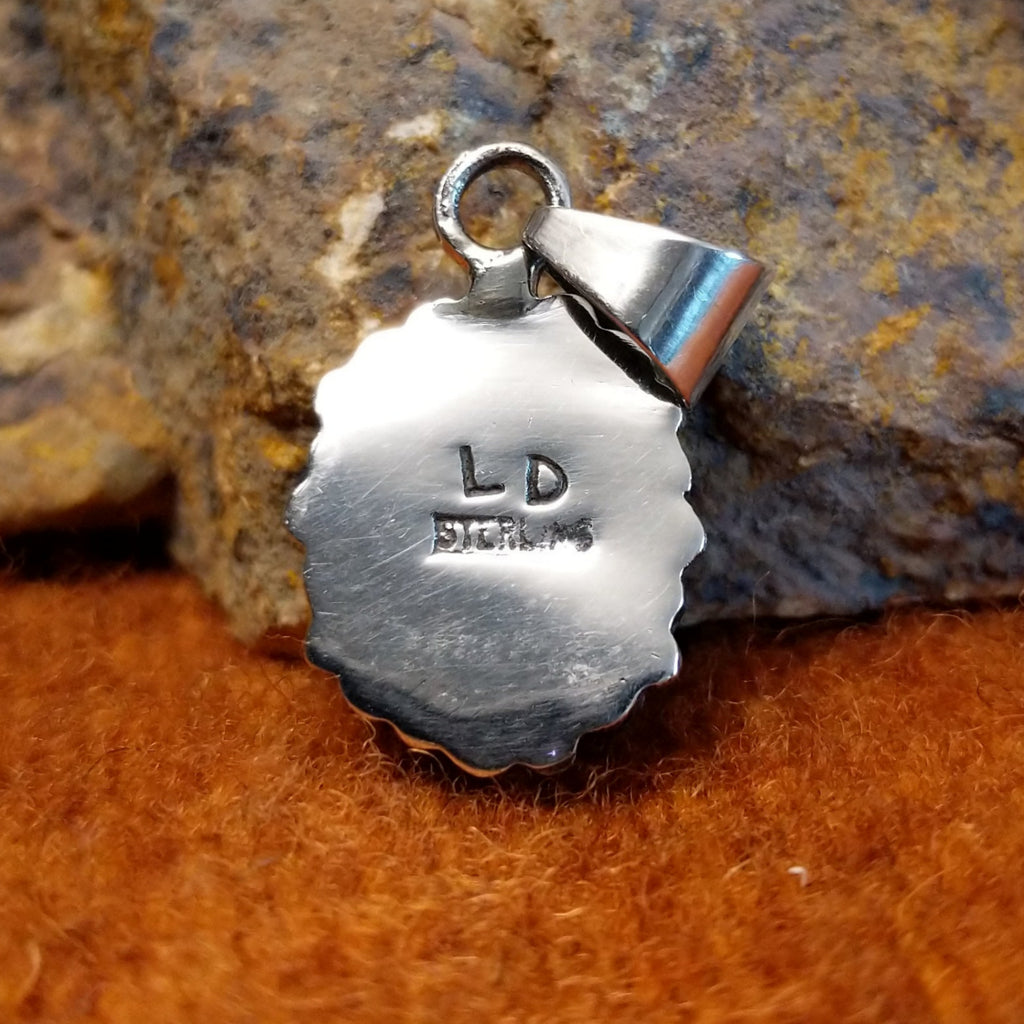 The artisan's initials are stamped on the back.