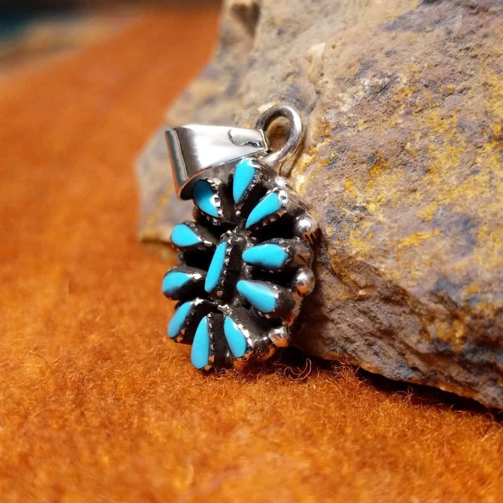 Turquoise set in petit point sterling silver pendant.