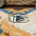 Handcrafted Navajo sterling silver ring featuring a rectangular Wild Horse gemstone with natural white, brown, and golden veining, set in a smooth bezel with openwork cutout details on the band; side view.