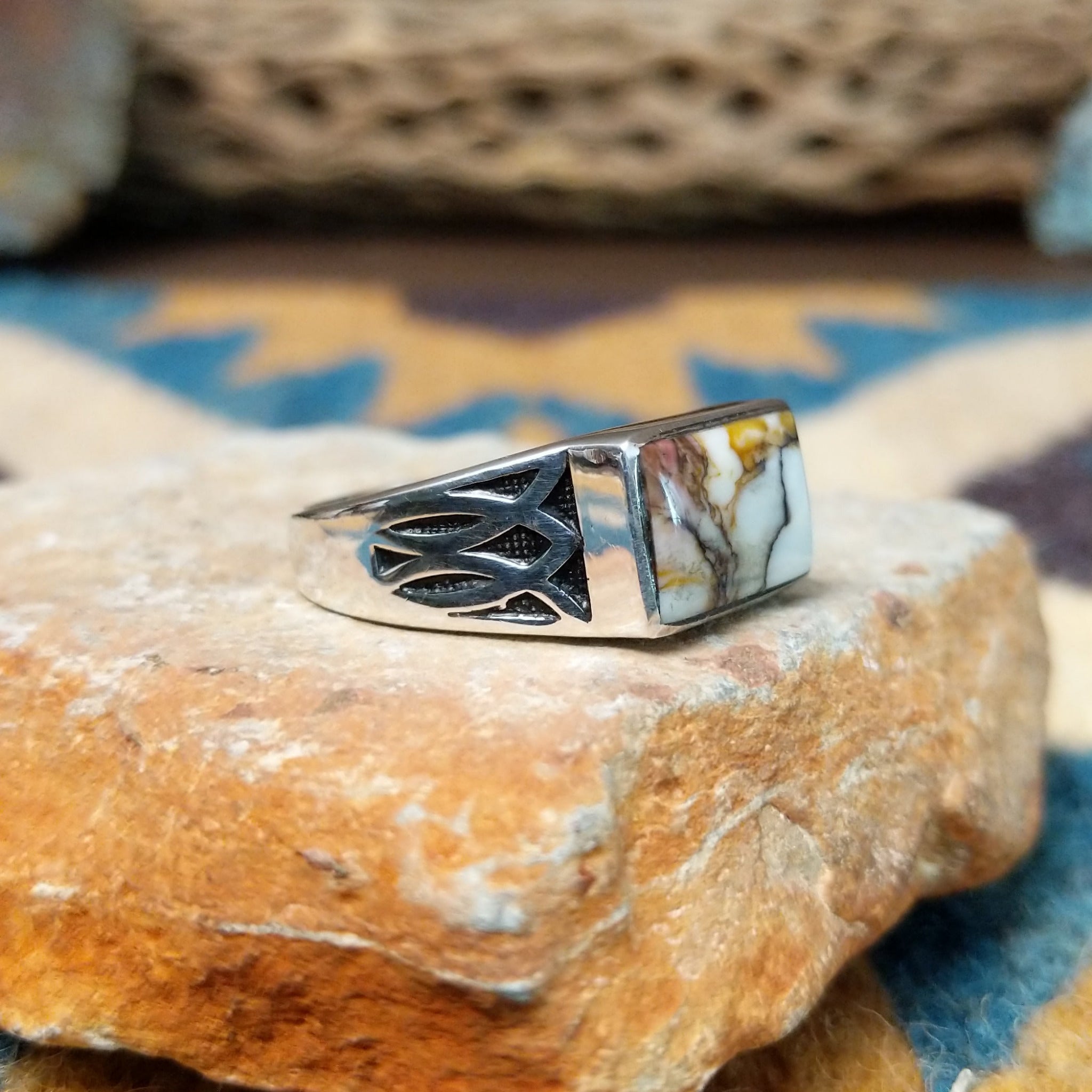 Handcrafted Navajo sterling silver ring featuring a rectangular Wild Horse gemstone with natural white, brown, and golden veining, set in a smooth bezel with openwork cutout details on the band; side view.