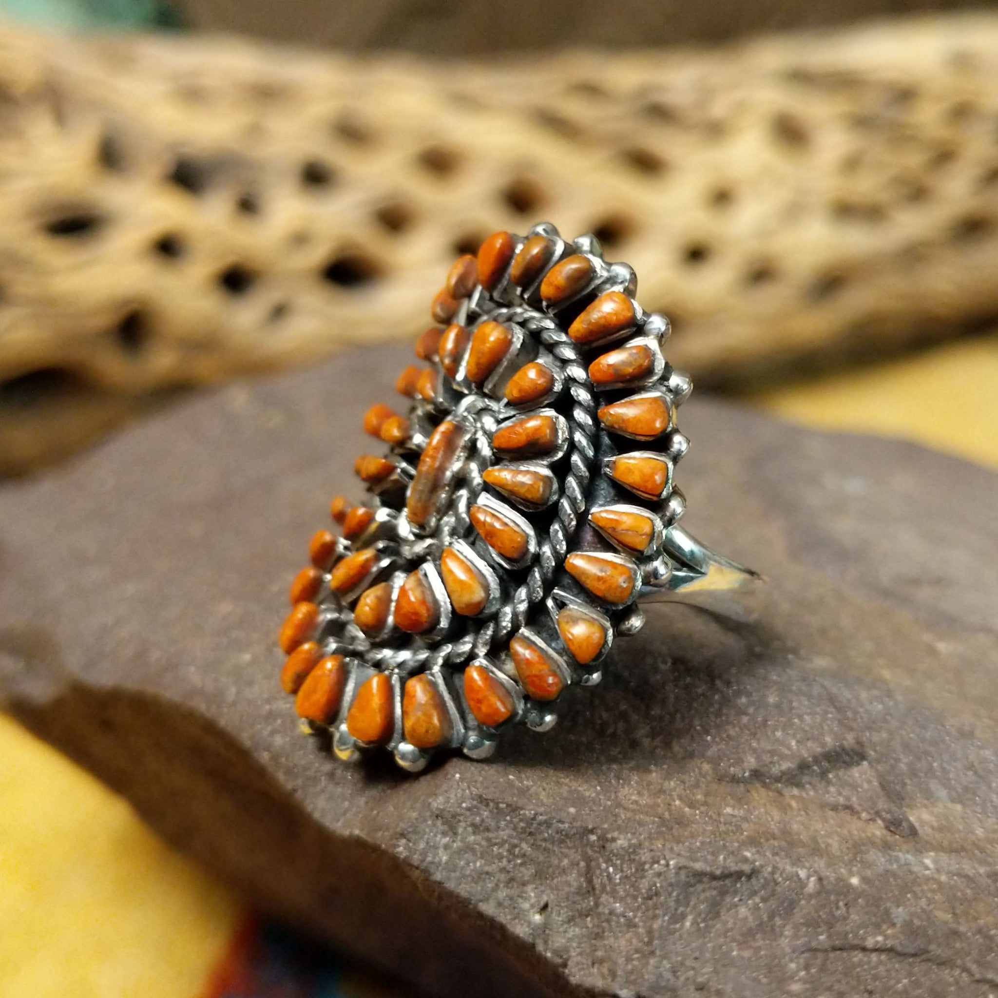 Navajo red spiny oyster shell concho ring, featuring a vibrant red spiny oyster shell set in a handcrafted sterling silver concho-style band with traditional Southwestern details.  Side view.