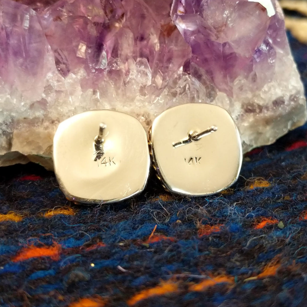 The back view of the earrings showcase the gold stamp.