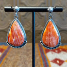 Sterling silver teardrop earrings with red spiny oyster shell set in the bezels, framed by dotted accents.