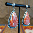 Sterling silver teardrop earrings with red spiny oyster shell set in the bezels, framed by dotted accents.