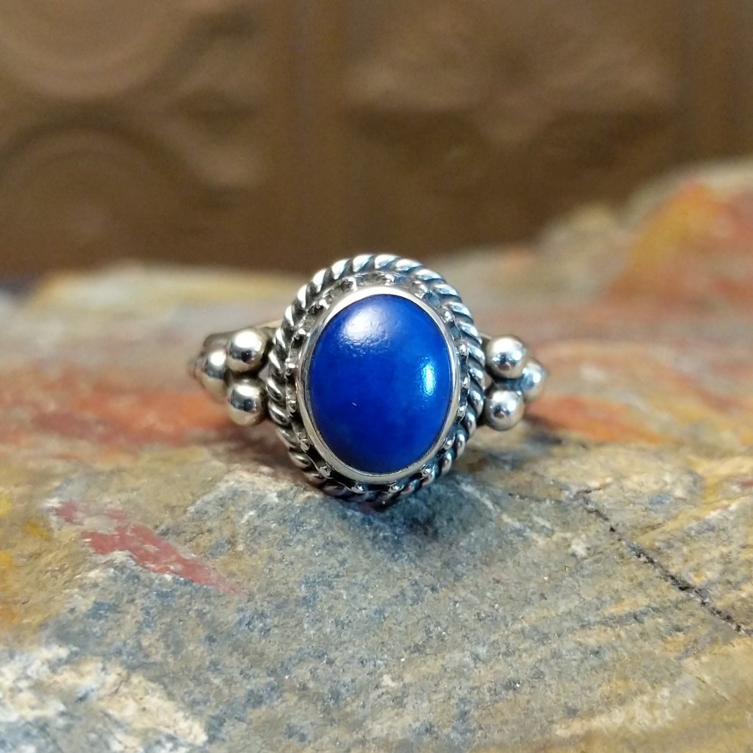 Sterling silver ring with lapis set in the round bezel, framed by twisted rope and dotted accents on the band.