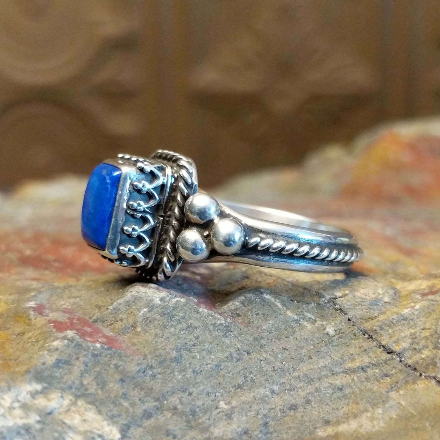 Sterling silver ring with lapis set in the square bezel, framed by twisted rope and dotted accents.