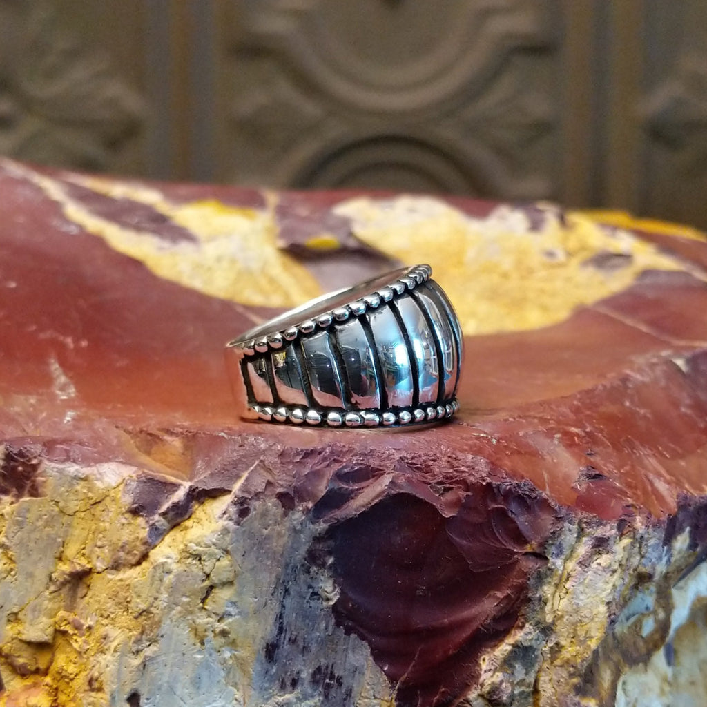 Sterling silver ring with a ribbed effect and dotted edges.