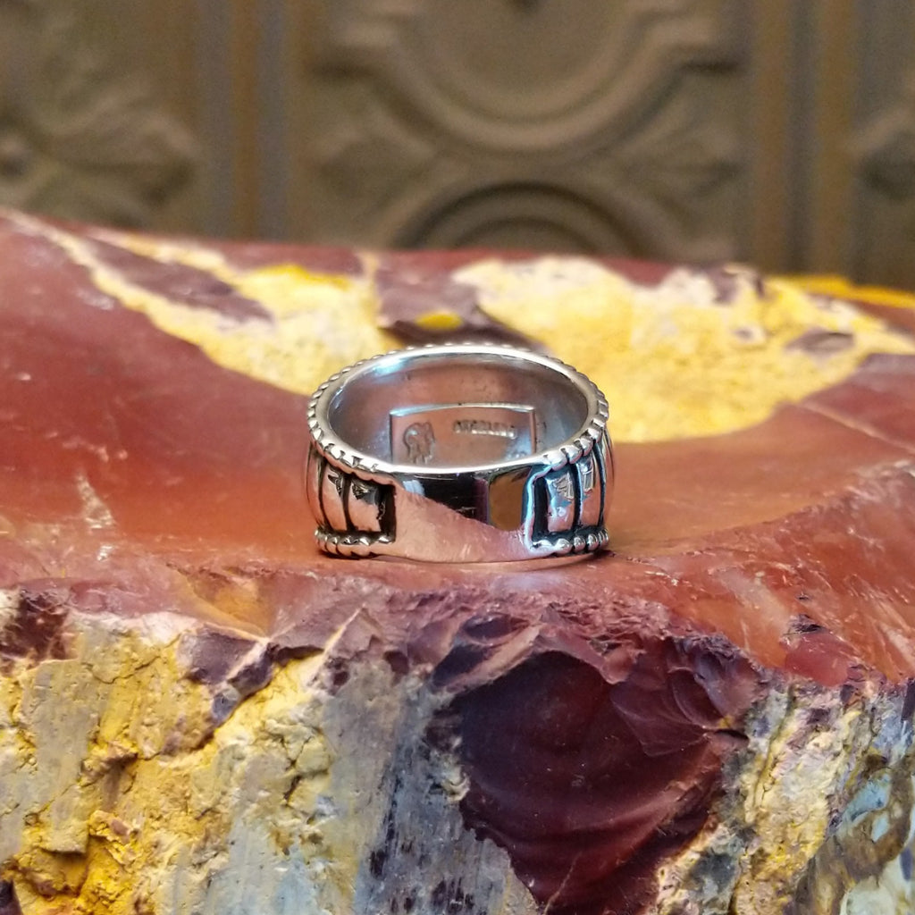 Sterling silver ring with a ribbed effect and dotted edges.