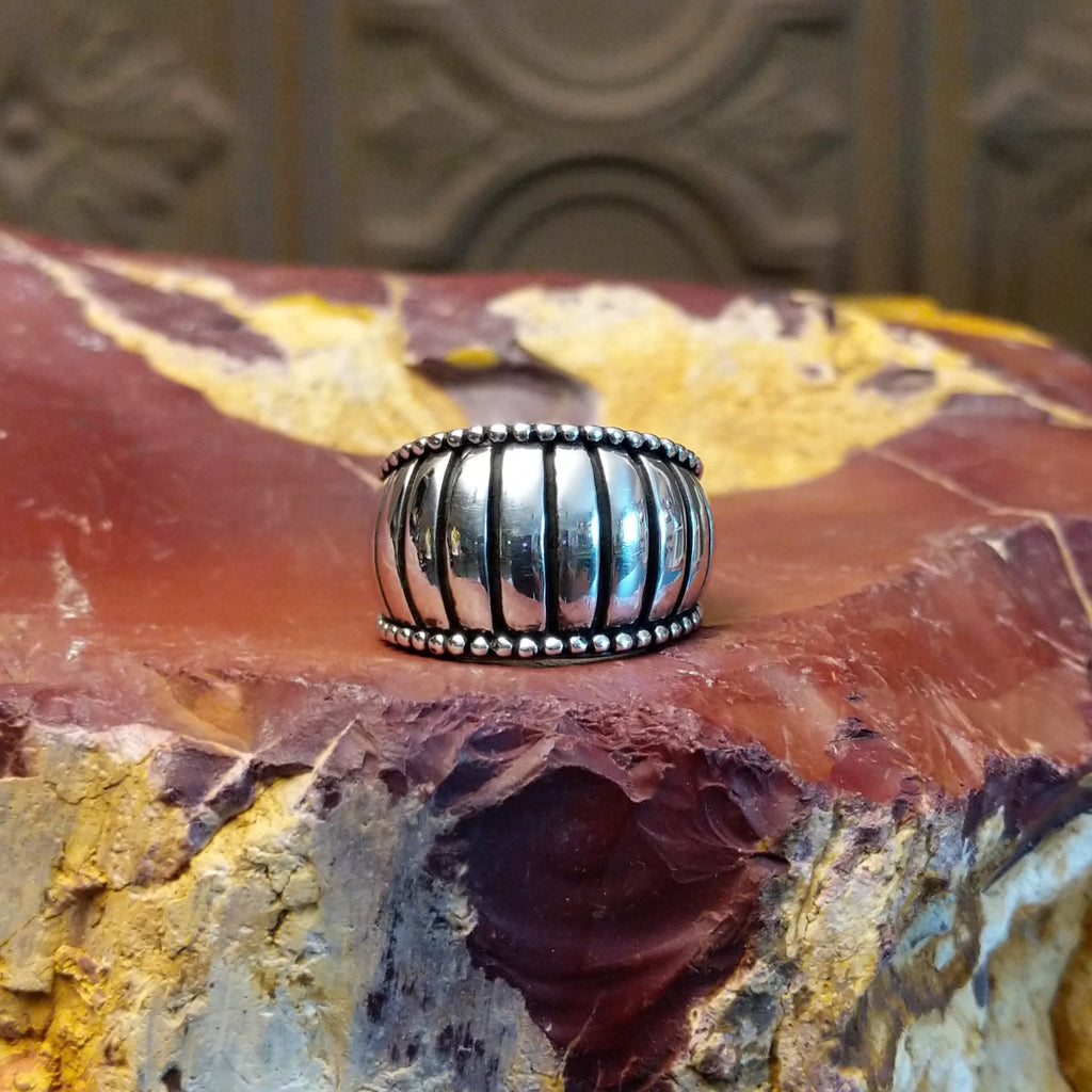 Sterling silver ring with a ribbed effect and dotted edges.