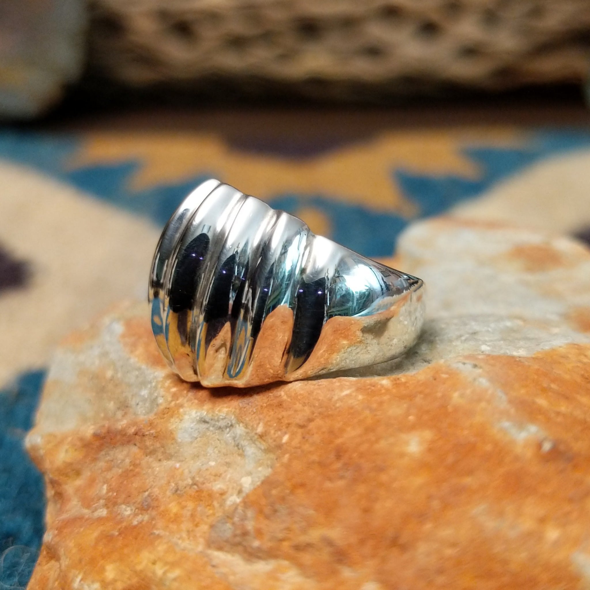 Handcrafted sterling silver Navajo ridged ring, featuring a polished domed design with bold vertical ridges; side view.