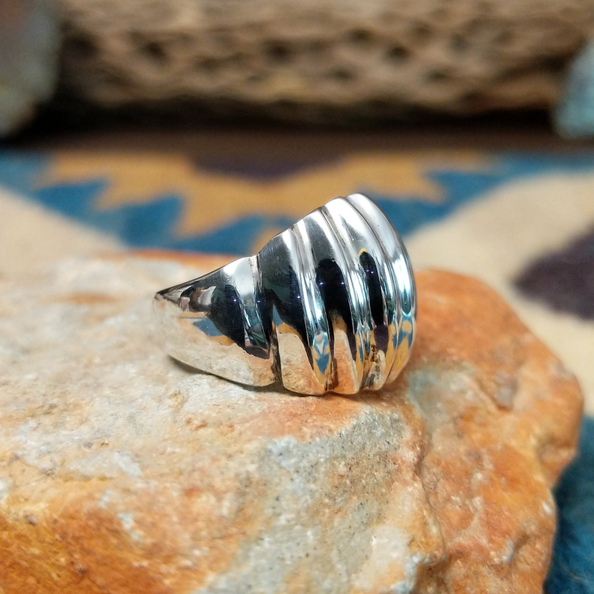Handcrafted sterling silver Navajo ridged ring, featuring a polished domed design with bold vertical ridges; side view.