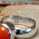Navajo sterling silver ring by W.B.V. featuring a smooth oval red coral cabochon set in a polished silver bezel and band; artisan and .925 (Sterling Silver) stamp.