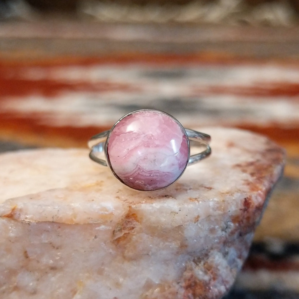 Round rhodochrosite set in sterling silver with polished layered band of the ring.