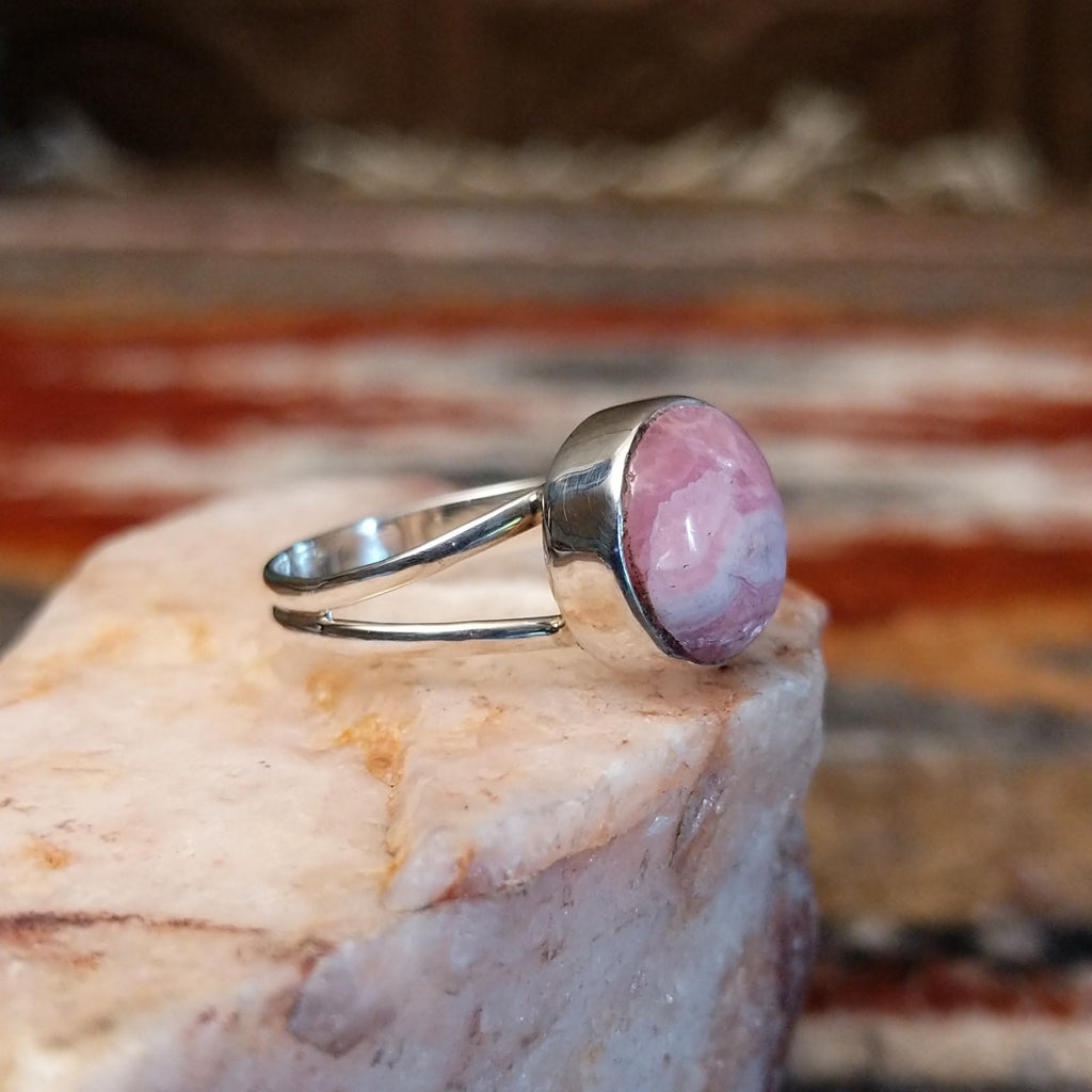 Round rhodochrosite set in sterling silver with polished layered band of the ring.