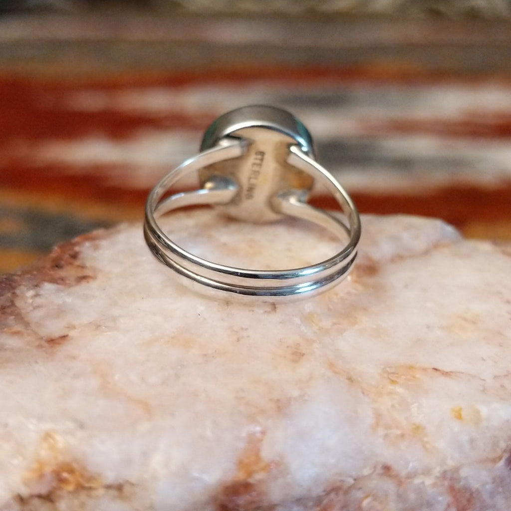 Round rhodochrosite set in sterling silver with polished layered band of the ring.