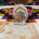 Navajo Silver Concho Ring with an elongated oval shape, raised diamond motifs, detailed stamped silverwork, oxidized accents, and a scalloped border; underside view.