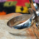 Navajo Silver Concho Ring with an elongated oval shape, raised diamond motifs, detailed stamped silverwork, oxidized accents, and a scalloped border; artisan and Sterling Silver stamp.