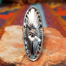Navajo silver concho ring with elongated oval face and radiating stamped design.