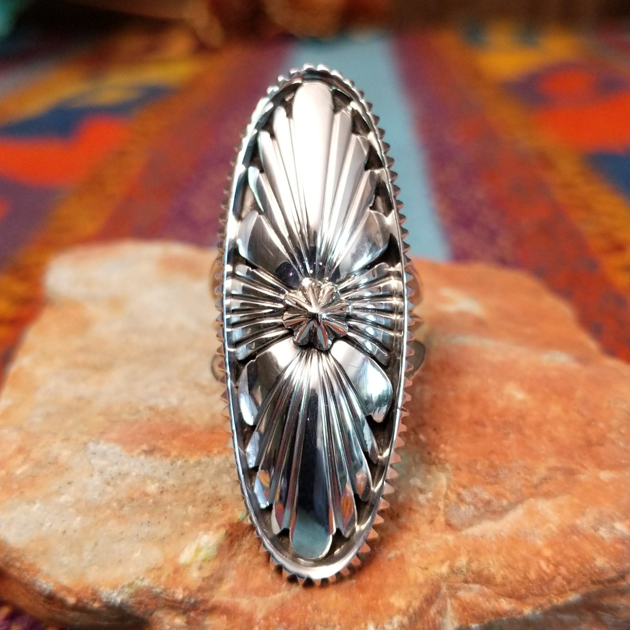 Navajo silver concho ring with elongated oval face and radiating stamped design.