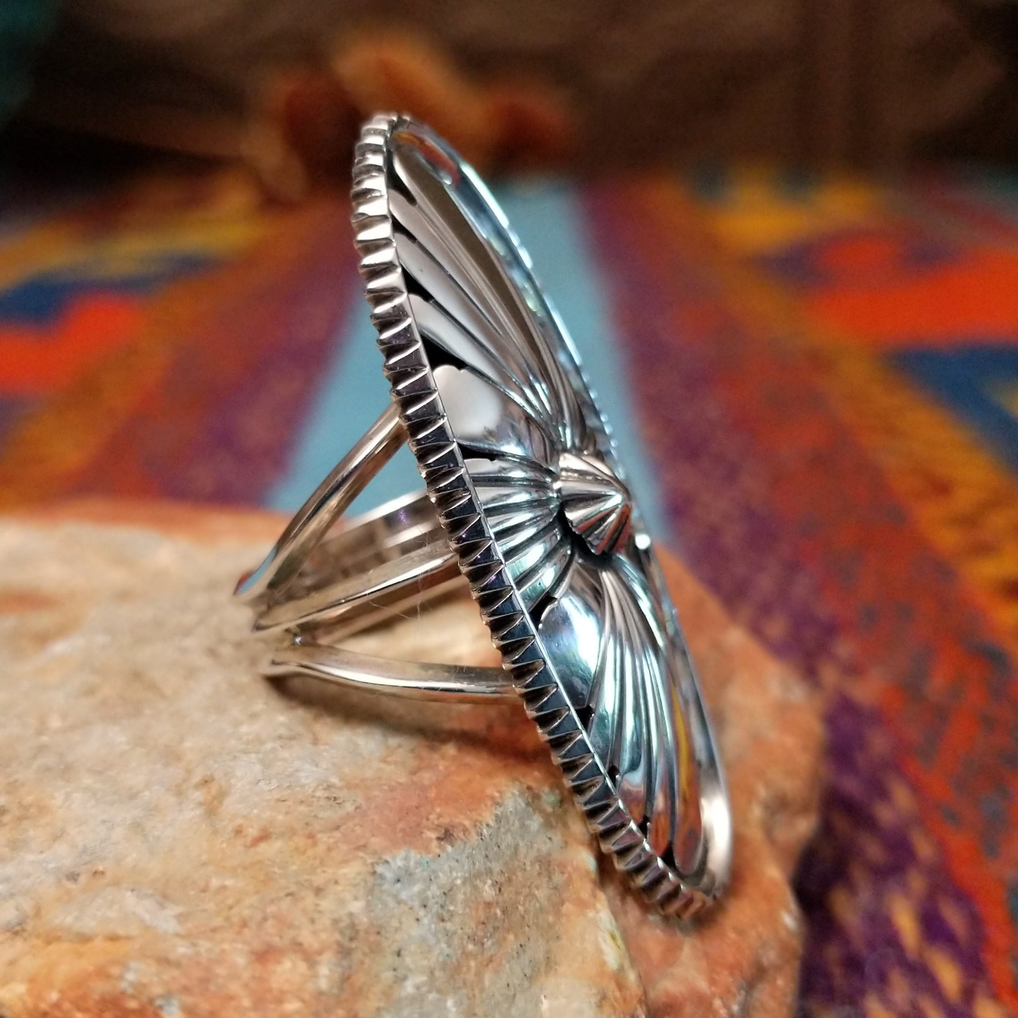 Navajo silver concho ring with elongated oval face and radiating stamped design.