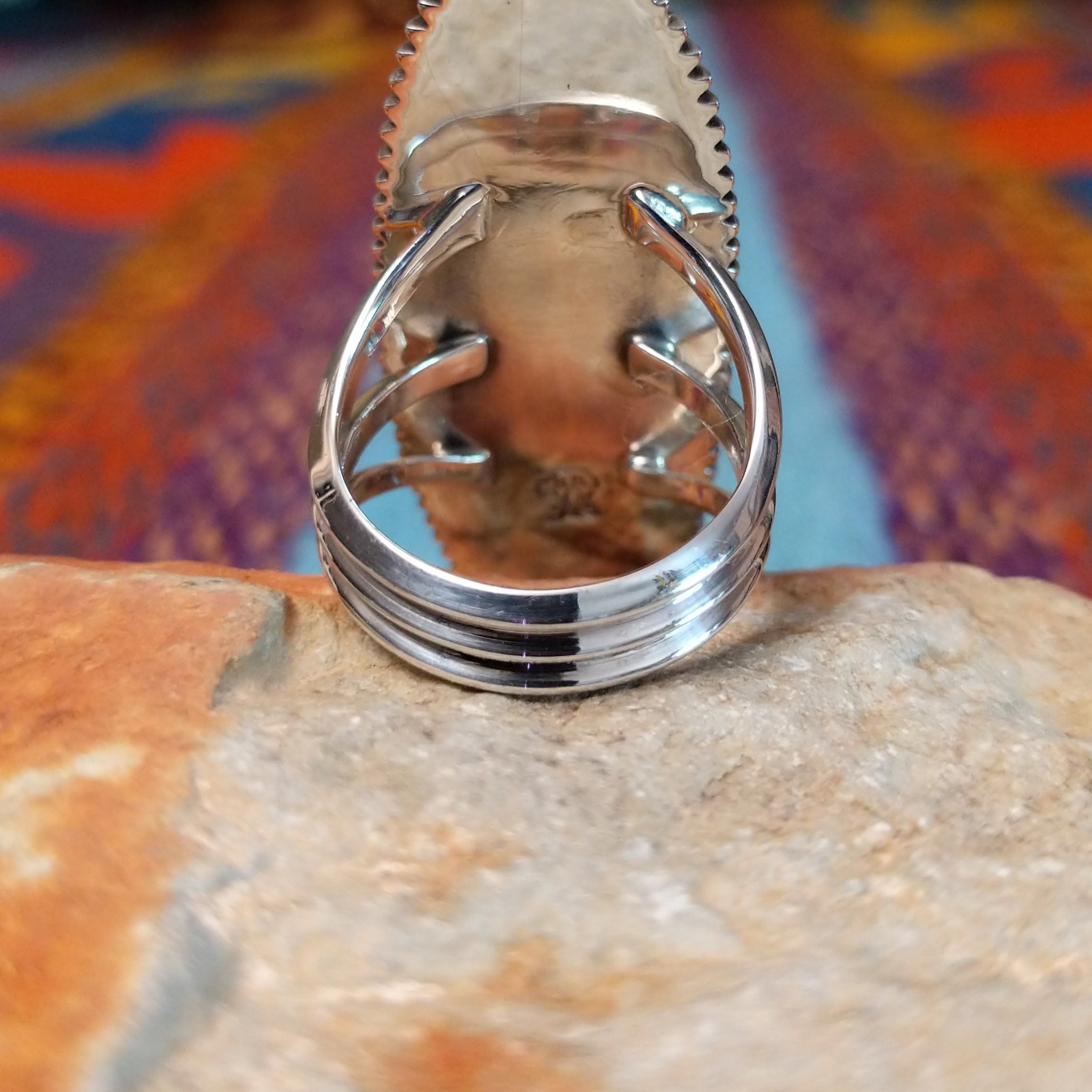 Navajo silver concho ring with elongated oval face and radiating stamped design.