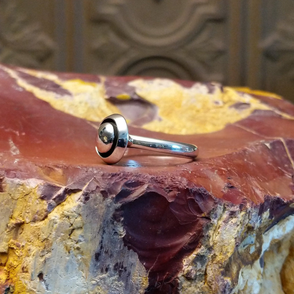 Sterling silver ring with dome centerpiece set in a shadowbox setting.