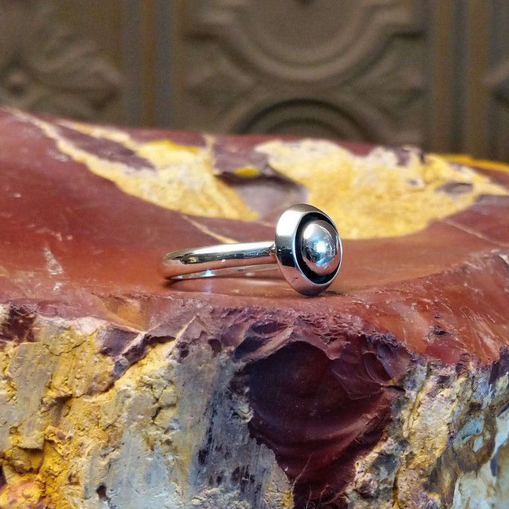 Sterling silver ring with dome centerpiece set in a shadowbox setting.