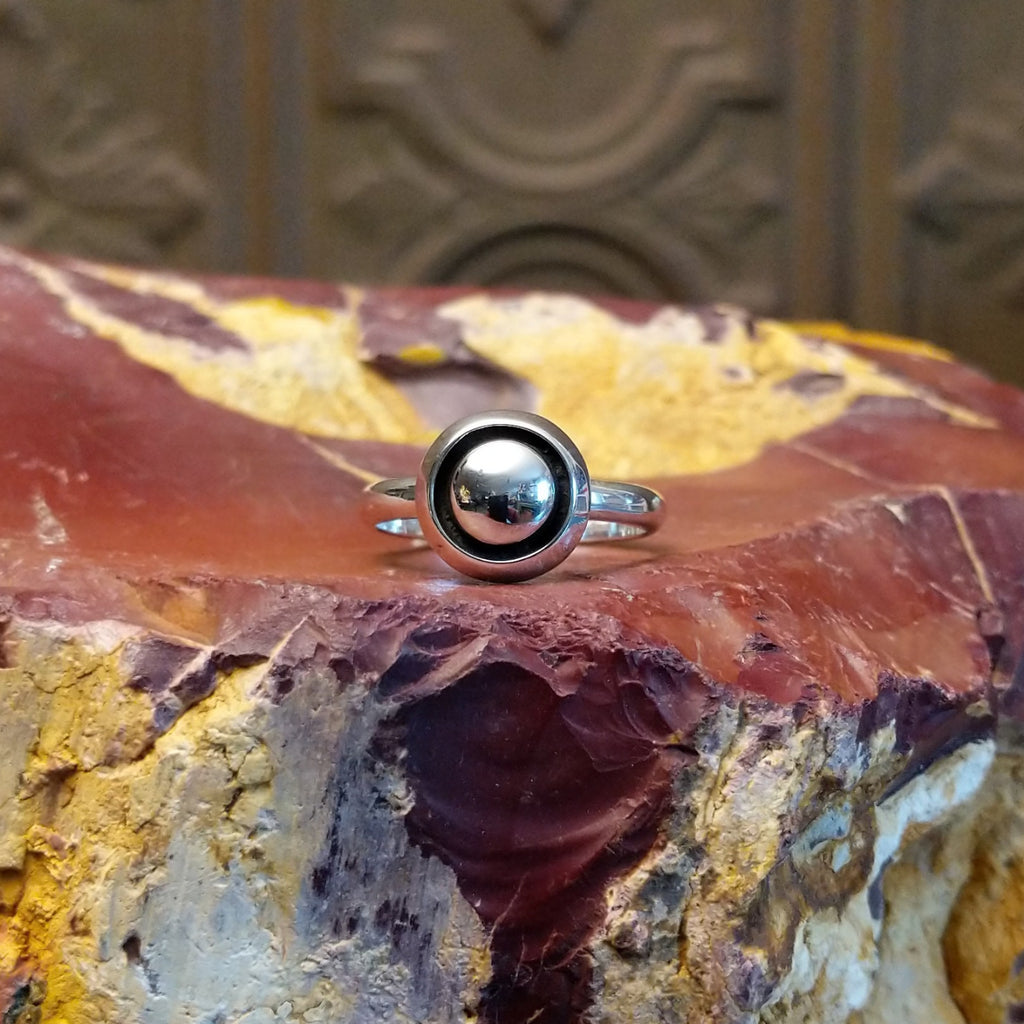 Sterling silver ring with dome centerpiece set in a shadowbox setting.
