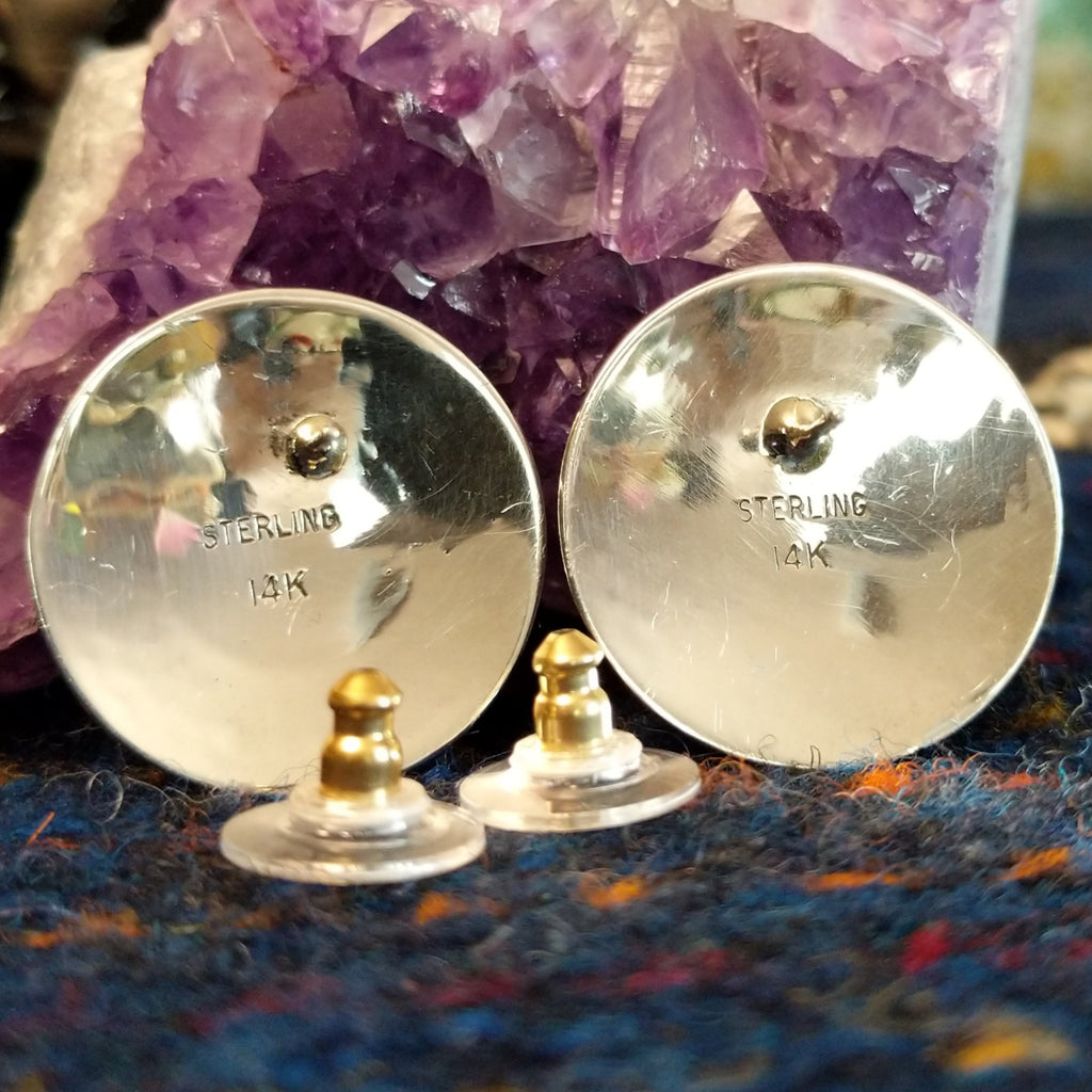 The back of the earrings showing the studs and the gold and silver stamps.