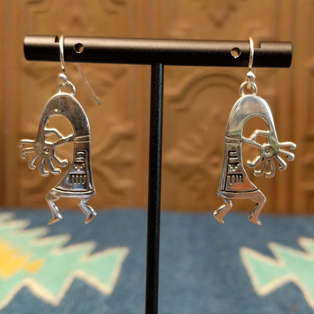 Sterling silver made into kokopelli figures with intricate designs as dangle earrings.