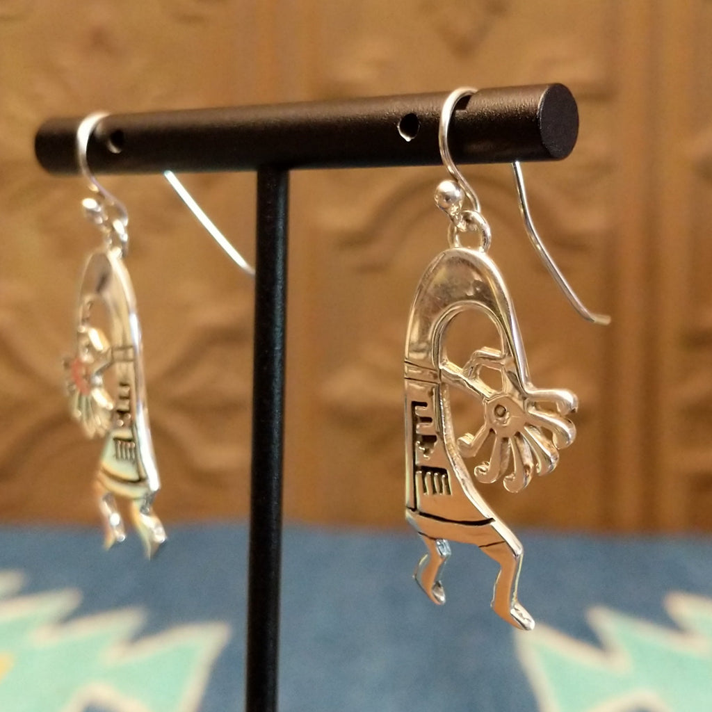 Sterling silver made into kokopelli figures with intricate designs as dangle earrings.