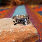 Navajo silver ring by I. Kee with Kokopelli figure and recessed geometric design.