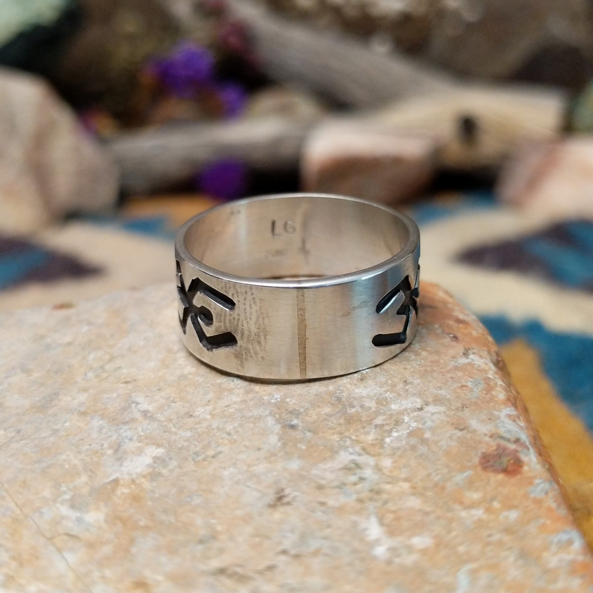 Sterling silver Navajo ring by L.G. with a brushed finish and hand-cut geometric design.