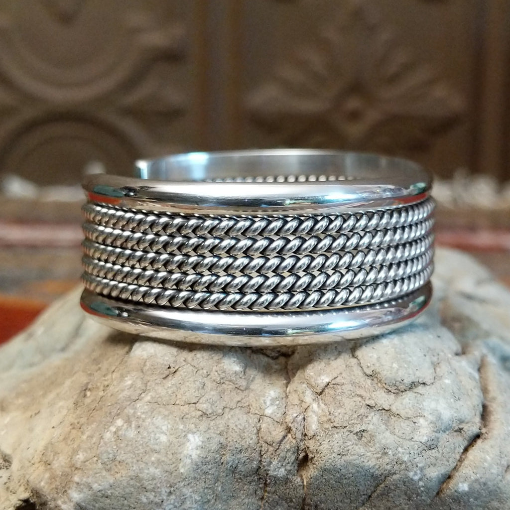 Sterling silver cuff with layered rope accents and polished finish.