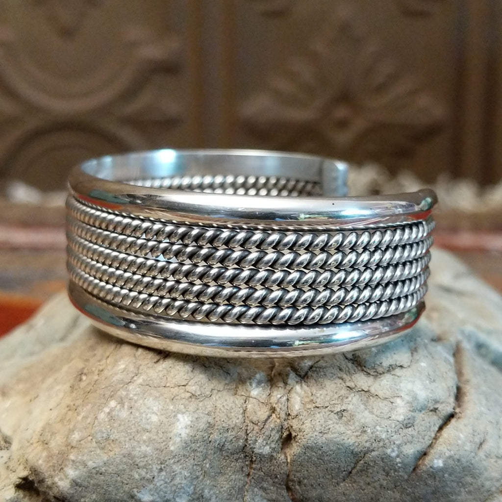 Sterling silver cuff with layered rope accents and polished finish.