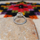 This Navajo Silver Star Ring features a round sterling silver face with a polished starburst design, dark oxidized background, beaded border, and textured silver band; underside view.